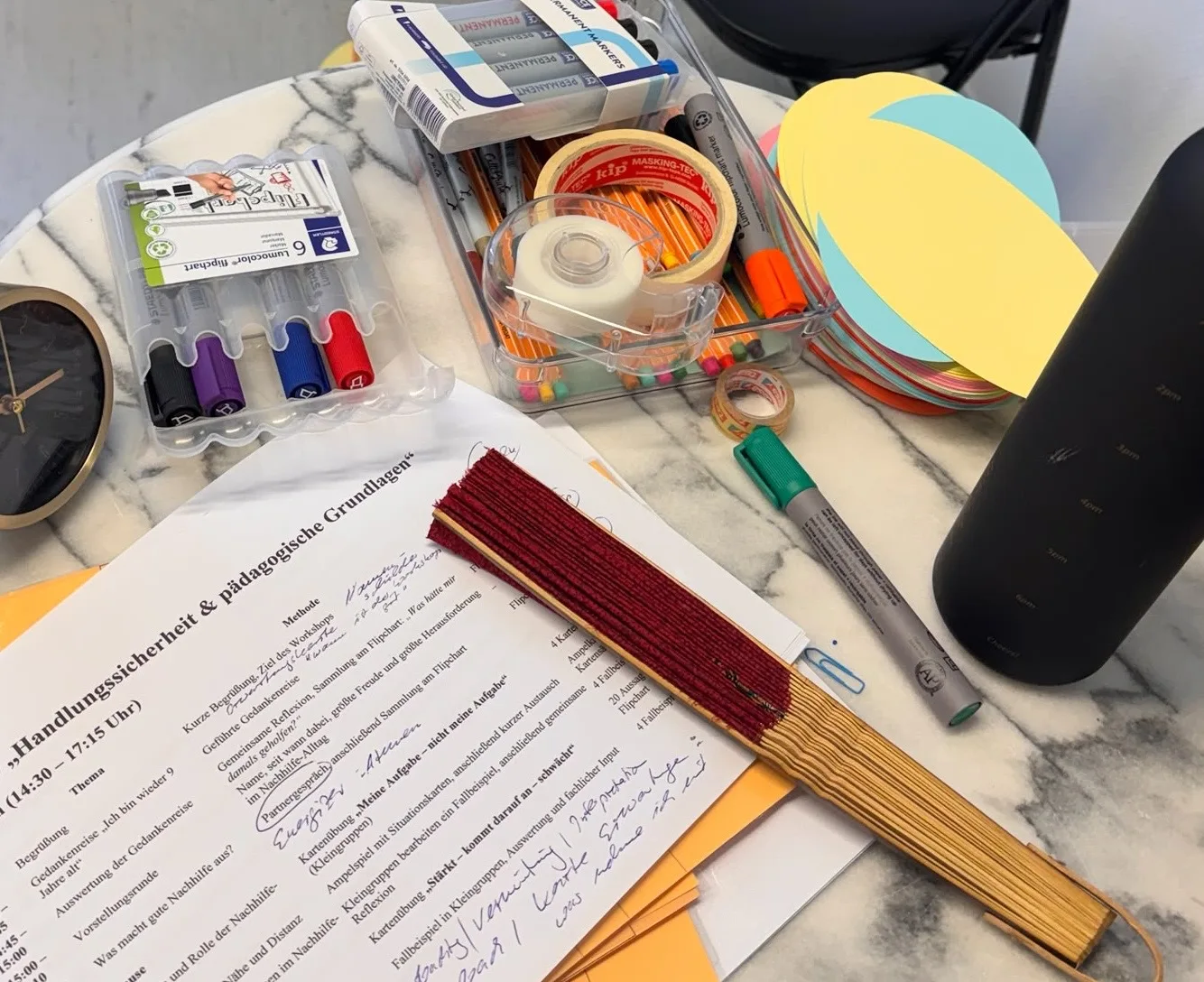 Workshop-Ablaufplan mit handschriftlichen Notizen, Stiften und farbigen Moderationskarten auf dem Tisch