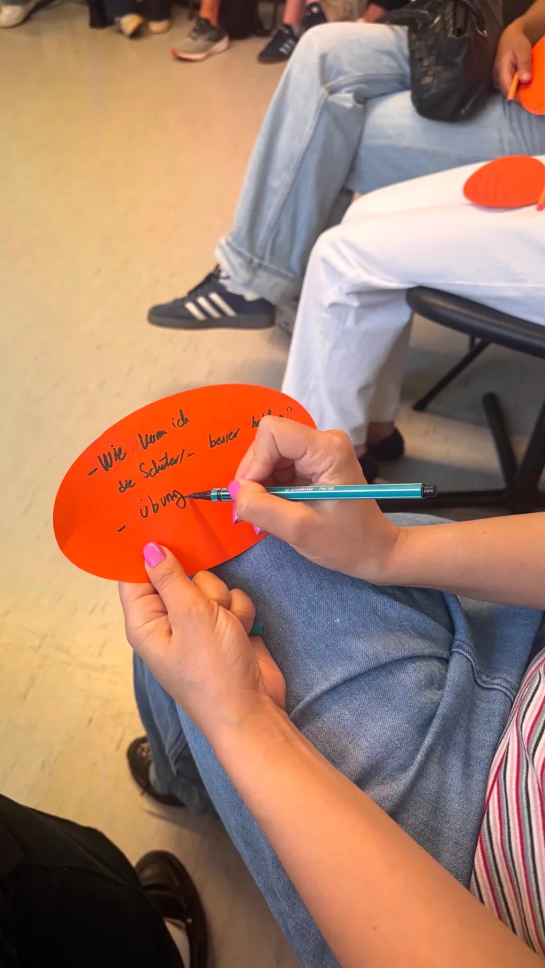 Lehrkraft notiert im Workshop ihre Frage, wie sie Schülerinnen und Schüler noch besser unterstützen kann, auf eine Moderationskarte