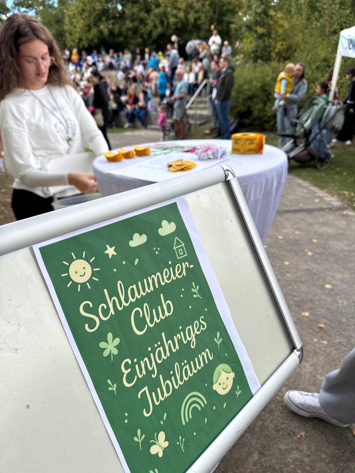 Aufsteller mit der Aufschrift Schlaumeier-Club Einjähriges Jubiläum vor dem Festgelände